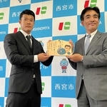 石井登志郎市長（右）から応援メッセージ入り絵馬を贈られた亀田和毅選手＝西宮市役所