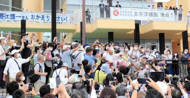 偉業を達成した堀江さんを祝福する人たち＝西宮市西宮浜４（撮影・斎藤雅志）＝西宮市西宮浜４