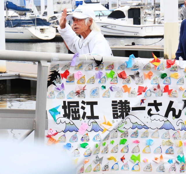 西宮浜義務教育学校の児童らが作った横断幕で飾られた桟橋を渡る堀江さん＝西宮市西宮浜４（撮影・斎藤雅志）