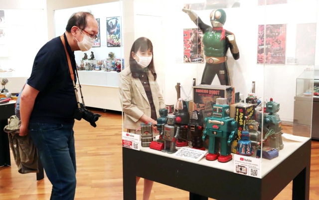 懐かしのおもちゃを眺める入館者＝芦屋市立美術博物館