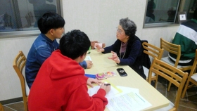 沖縄にルーツを持つ尼崎市在住者に聞き取り調査をする学生＝２０１９年、尼崎市（桃原教授提供）