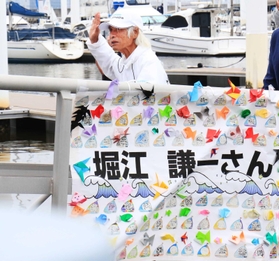 西宮浜義務教育学校の児童らが作った横断幕で飾られた桟橋を渡る堀江さん＝西宮市西宮浜４（撮影・斎藤雅志）
