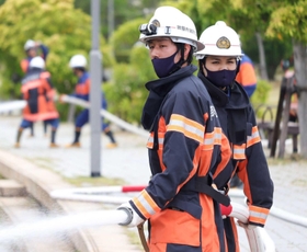 真剣な表情で放水訓練をする大学生の新原鴻平さん（左）と川満克己さん＝芦屋市南浜町