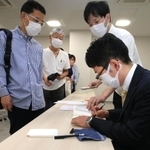 朝倉さん（手前右）のサインを求めて並ぶ来場者ら＝甲子園歴史館