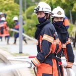 真剣な表情で放水訓練をする大学生の新原鴻平さん（左）と川満克己さん＝芦屋市南浜町