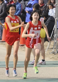 女子　尼崎市２区・新井志織選手（左）から３区・前田穂南選手にたすきが渡る＝２０１２年２月５日、加古川市防災センター前