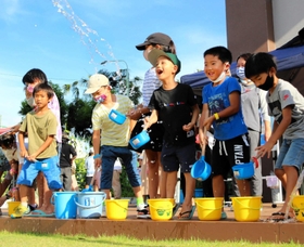 打ち水を体験する子どもたち＝立花南生涯学習プラザ