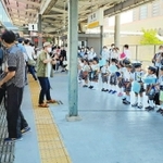 乗客に手作りのフラッグを振る園児＝ＪＲ宝塚駅