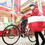 赤い球体をモチーフにした衣装を身にまとい、イベントに出る女性＝尼崎市建家町、三和本通商店街