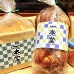 格子柄の色紙が巻かれたオリジナルの「潮江食パン」（提供）