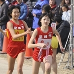女子　尼崎市２区・新井志織選手（左）から３区・前田穂南選手にたすきが渡る＝２０１２年２月５日、加古川市防災センター前