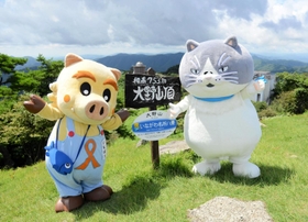 阪神地域の最高峰・大野山山頂で記念撮影するマル（右）といなぼう＝猪名川町柏原