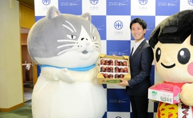 越田市長から川西市特産の朝採りイチジクを受け取るマル（左）＝川西市役所