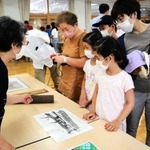 会場には落ちた焼夷弾も展示。見入る来場者＝西宮市浜脇町、浜脇小学校
