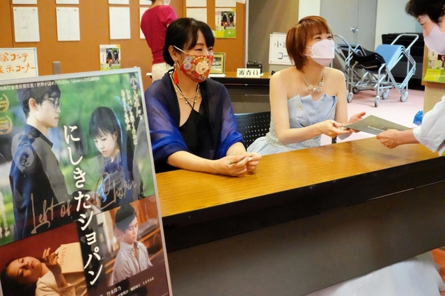 上映後、サインに応じる竹本祥乃監督（左）とピアニストの野々村亜梨沙さん＝西宮市民会館アミティ・ベイコムホール