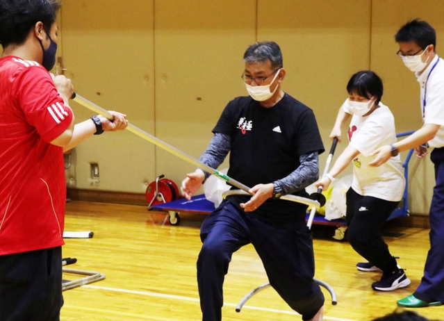 刺股も使い方次第。不審者役を務めた倉成進警部補を前後から押さえ込む教員ら＝西宮市立西宮支援学校