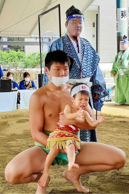 取組後も泣きやまない赤ちゃん＝越木岩神社