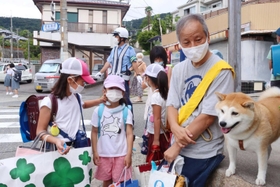 通学中の児童を見守る塩谷真さんと柴犬のおかき＝西宮市苦楽園五番町