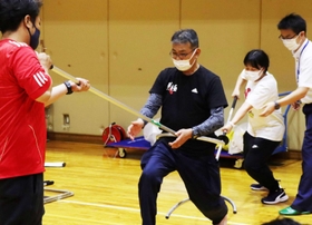 刺股も使い方次第。不審者役を務めた倉成進警部補を前後から押さえ込む教員ら＝西宮市立西宮支援学校