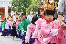 華やかな衣装に身を包み、保護者と一緒に歩く子どもら＝２２日、西宮市社家町
