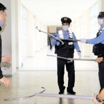 早く正確な通報が大切。すぐに駆け付けて不審者役を囲む警察官ら＝尼崎市立小園小学校