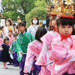 華やかな衣装に身を包み、保護者と一緒に歩く子どもら＝２２日、西宮市社家町