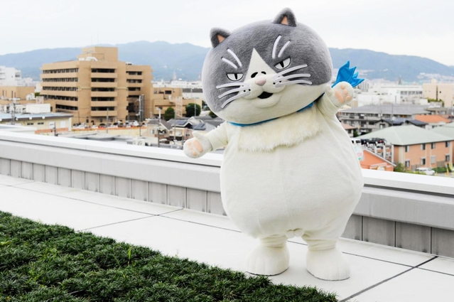 市街地を一望できる新庁舎３階屋上の緑地スペースに立つマル＝伊丹市役所