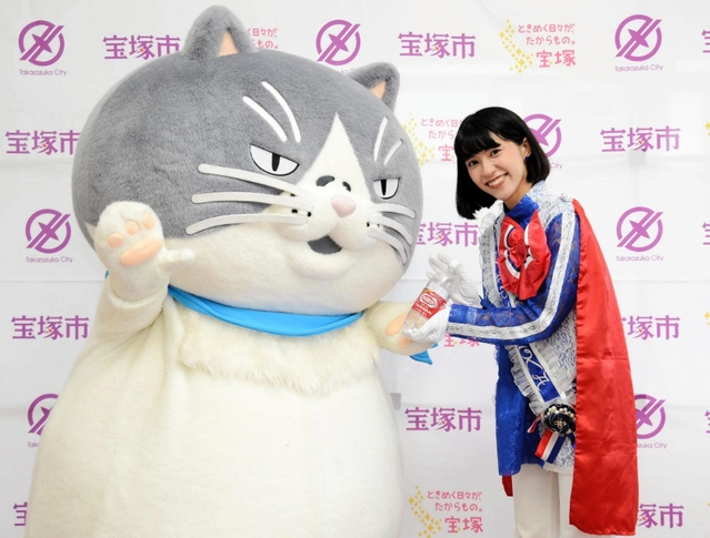 宝塚市観光大使リボンの騎士「サファイア」の御手洗菜々さんから炭酸水「ウィルキンソン　タンサン」をプレゼントされるマル＝宝塚市役所