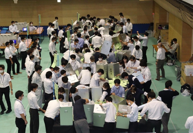 川西市長、市議選挙の開票作業をする職員＝１６日午後、川西市向陽台１、川西市市民体育館