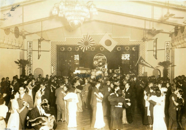 ダンサーの腰に手を回し、ホールで踊る来客たち（尼崎市立文化財収蔵庫提供）