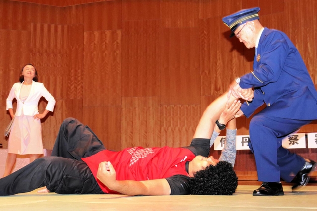 クレーマーの女を取り押さえる警察官役の福田和雄署長（右）＝伊丹アイフォニックホール