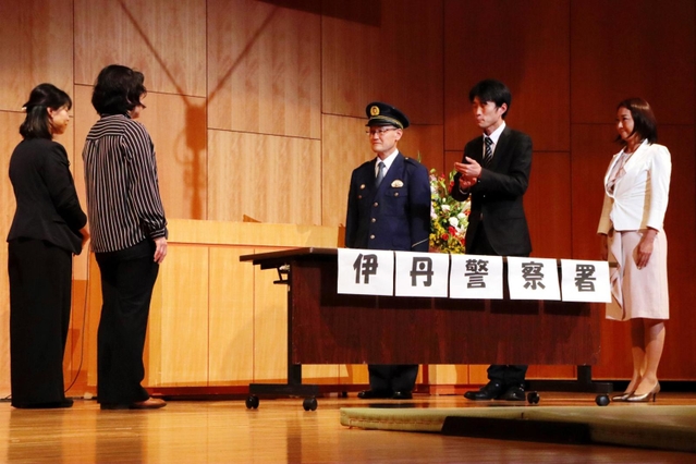 伊丹署に相談しに来たスナック店長と工場事務員に警察官が対応する場面＝伊丹アイフォニックホール