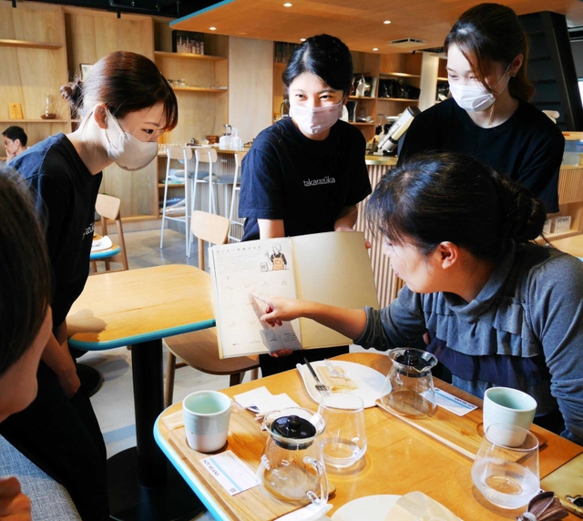お客さんに「コーヒー診断テスト」を勧める武庫川女子大学の学生＝宝塚市仁川北３