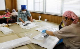 袋の組み立てなどの軽作業も、驚くほどの速さで進めていく＝尼崎市久々知２