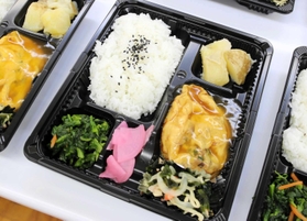 この日のメニューはかに玉と、栄養バランスを考えた野菜の副菜＝尼崎市久々知２