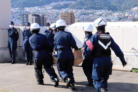 訓練で負傷者役を運び出す署員ら＝芦屋市公光町、芦屋署