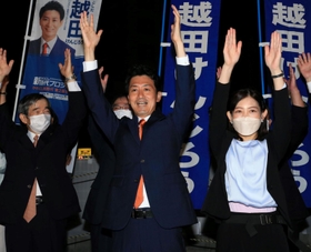 再選を確実にし、支援者らと万歳する越田謙治郎氏。伊丹市の藤原保幸市長（左）らも祝福に駆け付けた＝川西市小戸１（撮影・斎藤雅志）