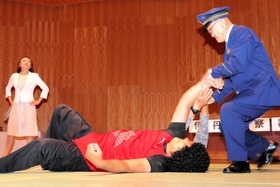 クレーマーの女を取り押さえる警察官役の福田和雄署長（右）＝伊丹アイフォニックホール