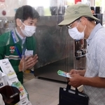 訓練で高齢男性に詐欺であることを伝える平井光也店長（左）＝セブン－イレブン西宮マリナパーク店