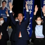 再選を確実にし、支援者らと万歳する越田謙治郎氏。伊丹市の藤原保幸市長（左）らも祝福に駆け付けた＝川西市小戸１（撮影・斎藤雅志）