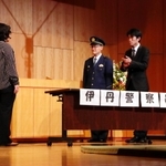 伊丹署に相談しに来たスナック店長と工場事務員に警察官が対応する場面＝伊丹アイフォニックホール