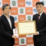 幼稚園バスの安全装置の設置に役立ててもらおうと１千万円を寄付した「ゼロプラス」の大場正樹社長（右）＝伊丹市役所