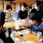 お客さんに「コーヒー診断テスト」を勧める武庫川女子大学の学生＝宝塚市仁川北３