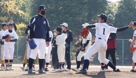 井川慶さん（左）から投球のコツを教わる生徒＝芦屋市芦屋中央公園野球場