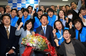 初当選を確実にし、稲村和美市長（前列左から２人目）や支援者らと喜ぶ松本真氏（前列中央）＝尼崎市七松町３（撮影・斎藤雅志）