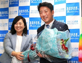 初当選を確実にし稲村和美市長（左）から花束を受け取る松本真氏＝２０日夜、尼崎市七松町３（撮影・斎藤雅志）