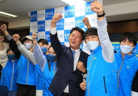 初当選を確実にして支援者らと喜ぶ松本真氏（中央）＝２０日夜、尼崎市七松町３（撮影・斎藤雅志）