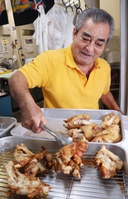 トングで豚足をつかむ店主の大城徳幸さん＝尼崎市玄番北之町