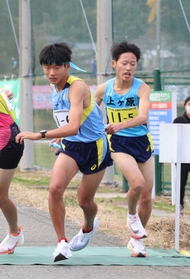 上ケ原の５区近内虎一選手（右）からたすきを受け取る６区天神幸之丞選手＝豊岡市日高町（撮影・長嶺麻子）