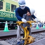 ハンドタイタンパーを操作する親子連れ＝尼崎市北城内、阪神電車尼崎車庫